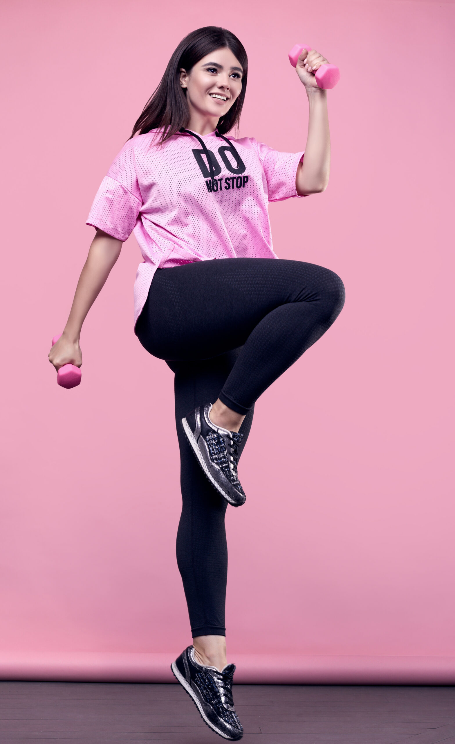 ?orgeous body positive latin woman in a pink hoodie with dumbbells